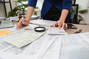 Accountant calculating taxes with a magnifying glass and calculator photo
