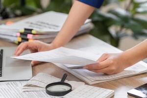 Close-up of accountant's hands sorting tax documents on a desk. photo
