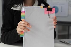 Accountant holding organized financial documents with colorful tabs for easy reference. photo