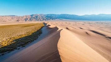 Sweeping aerial view of desert sand dunes and vast mountain range background photo