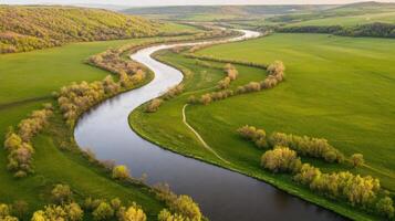 Aerial view of winding river flowing through lush green countryside landscape photo
