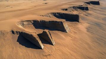 Aerial view of eroded desert landscape with dramatic sand formations and shadows photo