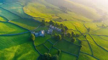 Aerial view of lush green fields and stone farmhouses in countryside landscape photo