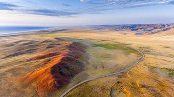 Aerial view of expansive desert landscape with rolling hills and clear sky photo
