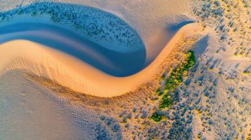 Aerial view of sand dunes with unique curves and patterns in desert landscape photo