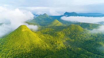 Aerial view of lush green mountains surrounded by misty clouds in tropical landscape photo
