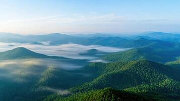 Aerial view of misty mountain ranges with dense forest and morning sky photo
