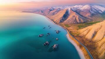 Aerial view of coastal mountain range with snow-capped peaks and turquoise waters photo