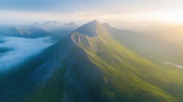 Majestic mountain range at dawn with clouds and sunlight casting shadows photo