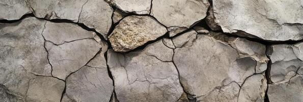 Cracked gray stone wall with weathered texture and natural details photo