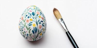 Painted easter egg with colorful floral design and paintbrush for art creativity photo