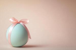 Pastel blue egg with pink ribbon bow on a soft background celebrating easter photo