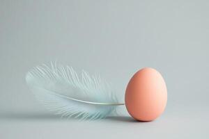 Minimalist pastel composition featuring egg with feather on soft background photo