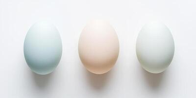 Three pastel colored eggs arranged in a row on a white background photo