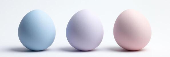 Three pastel colored eggs in blue, purple, and pink on a white background photo