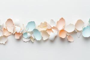 Pastel-colored eggshells arranged in a horizontal pattern on white surface photo