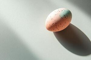 Speckled easter egg on minimalist light green background with shadows photo