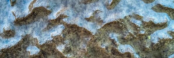 Abstract aerial view of snow covered landscape with frozen lakes and forest photo