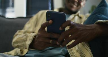 A man is smiling while using his cell phone video