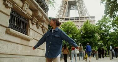 un' donna nel un' denim giacca è in piedi nel davanti di il eiffel Torre video
