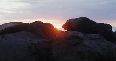 Sunset over the ocean with rocks and rocks video