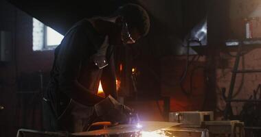 A man is welding metal in a factory video