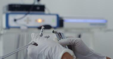 Close-up of the assembly of a medical instrument for the work of an otorhinolaryngologist, an unidentified person, only the doctor's hands are visible. in 4k, red komodo. video