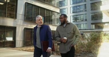 Two men walking in front of a building video