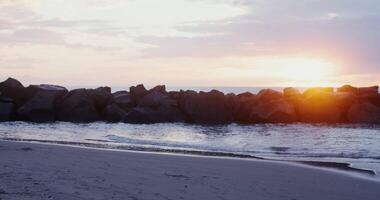 A man is walking on the beach with a backpack video