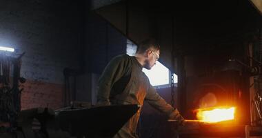 A man is working on a hot metal object video