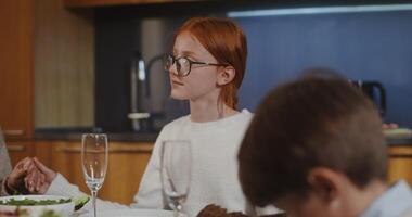 A woman and two children sitting at a table with a plate of food video