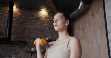 A woman is holding a dumbbell in her hand video