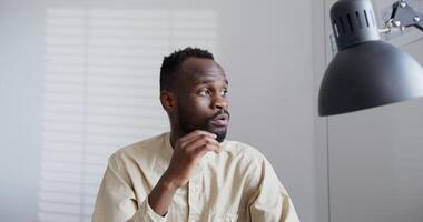 A man is sitting in front of a lamp video