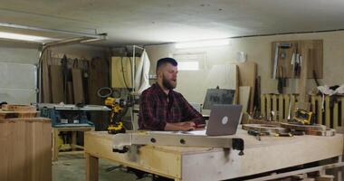 A man sitting at a table with a laptop computer video