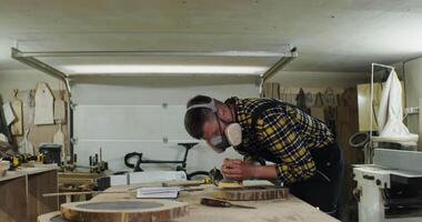 A man working on a wooden piece in a workshop video