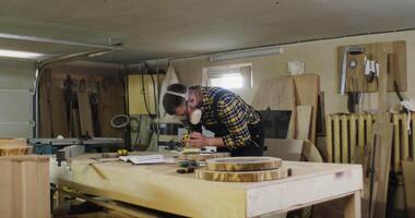 A man working on a wooden table in a workshop video
