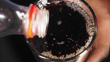 Pouring a refreshing dark beverage into a glass on a table video