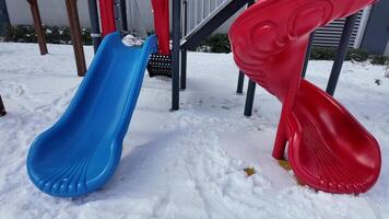 Colorful slides in a snowy playground during winter fun video