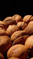 Walnut nuts food, closeup of walnut nut texture on black background, brown walnut nuts food video