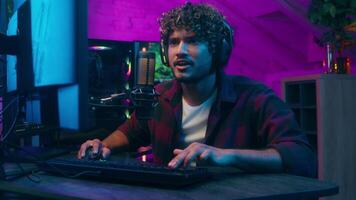 Excited Arabian Latino man cyber sport streamer computer game player web happy guy victory winner competition addict male talking microphone broadcast influencer blogger enjoy match e-sport play pc video