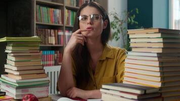 Pensive thoughtful girl woman Caucasian female thinking idea learning studying high school student teacher tutor books in library education course class prepare lesson think ponder university college video