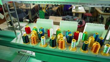 Industrial machines with colorful sewing thread. Rows spools of thread of different colors in the industrial sewing machine video