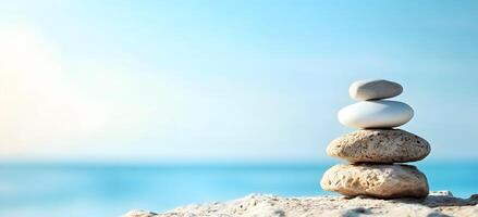 Stacked Stones on Sandy Beach with Serene Ocean Horizon photo