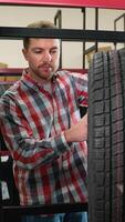 Man selecting a tire from the shelf in auto parts store video