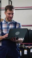 Warehouse worker checking tire inventory on a laptop video