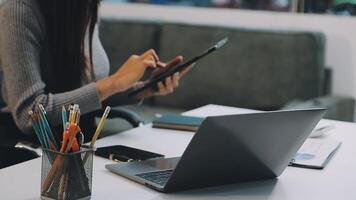 A woman is using a tablet computer at a desk video