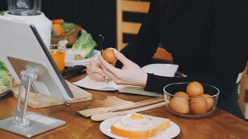 A woman is using a tablet to make an egg video