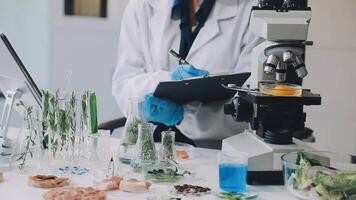 A woman in a lab coat is looking at a microscope video