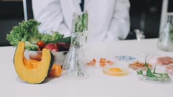 A person in a lab coat is standing next to a table with various food items video