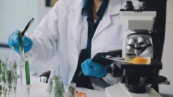A person in a lab coat is working on a test tube video